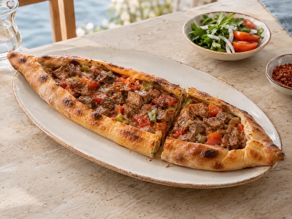 Oval seramik tabakta kuşbaşılı pide; temsili sunum