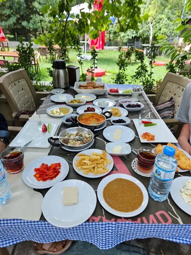 Altınsu bahçesinde çeşitli tabaklar ve çay bardaklarıyla hazırlanmış uzun bir sofra