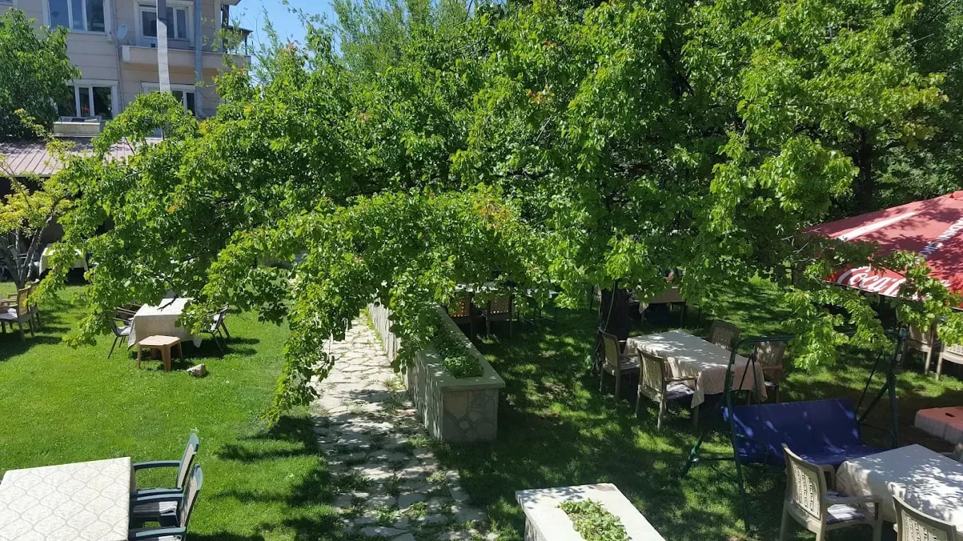 Altınsu bahçesinde yeşil ağaçlar arasında masa ve oturma alanları